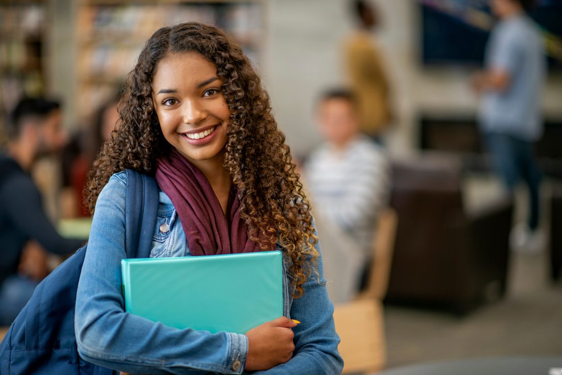 Lycéenne souriante avec son classeur, élève du soutien scolaire
